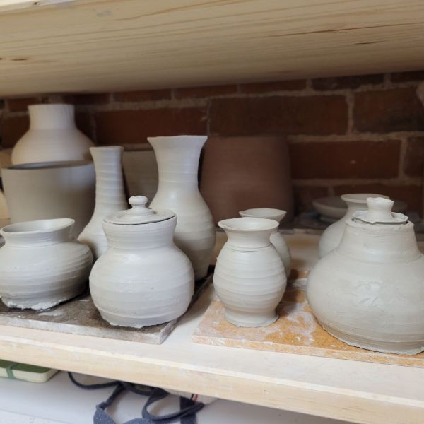 A collection of small greenware vessels thrown on the potter's wheel.