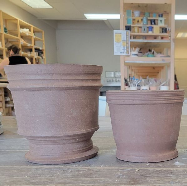 Two medium sized greenware plant pots made with red clay.