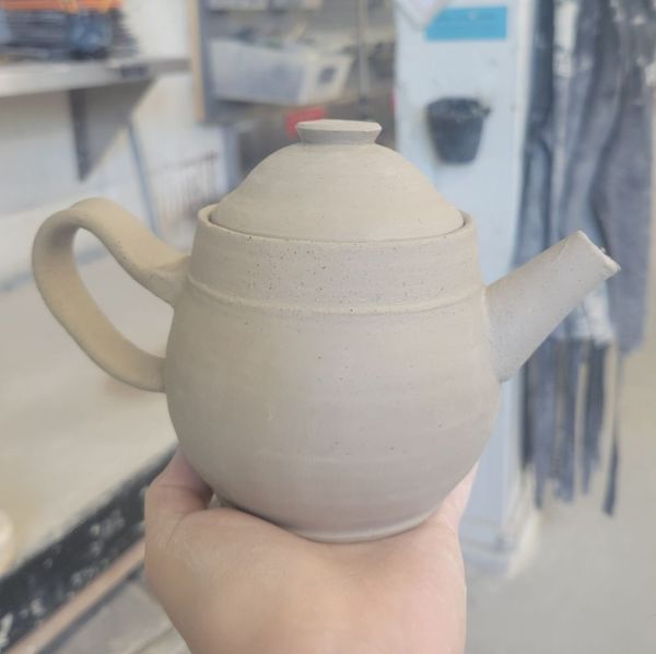 A small greenware teapot.